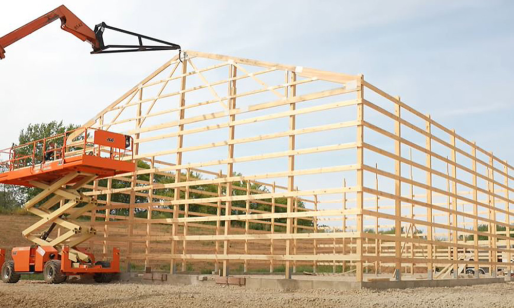 Post_Frame-07 scissor crane placing wood trusses on post frame construction barndominium